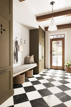 a black and white checkered tile floor in a hallway with two benches on either side