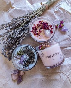 lavender and chamomi candle surrounded by other items on wax paper with dried flowers