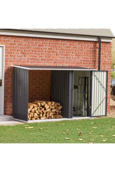 a large stack of logs in front of a brick building