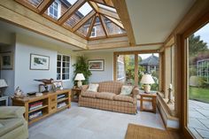 a living room filled with lots of furniture under a skylight next to a window