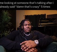 a man with dreadlocks sitting on a couch