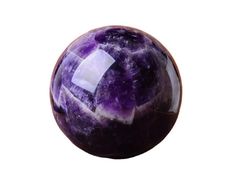 a purple marble ball sitting on top of a white surface