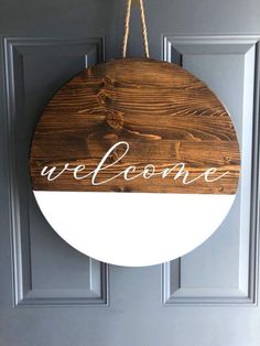 a welcome sign hanging from the front door with rope on it's end and an inscription that reads, we welcome