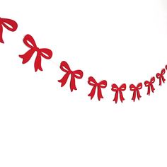 red paper bows are hanging on a string