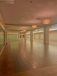 an empty room with tiled floors and lights