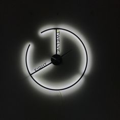 a clock that is lit up in the dark with light coming from it's sides