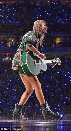 the singer is singing in the rain with her guitar