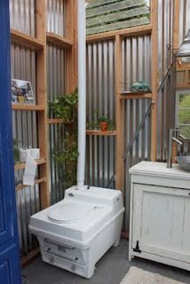 a room filled with lots of wooden shelves next to a white sink and blue door