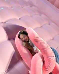 a woman laying on top of a pink inflatable couch