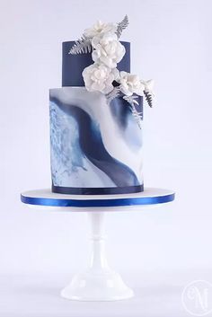 a blue and white cake with flowers on top