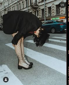 a woman in fishnet stockings bending over on the street