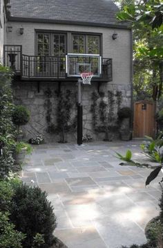 an outdoor basketball court in front of a house