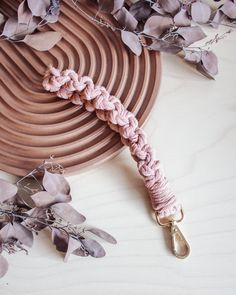 a close up of a pink leash on a table with purple flowers and metal scissors