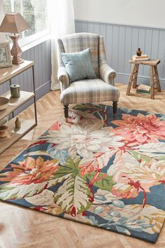 a living room filled with furniture and a large rug on top of a hard wood floor