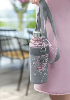 a pink and gray bag hanging from the side of a pole with a camera attached to it