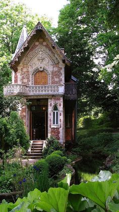 an old house in the woods surrounded by greenery