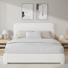 a white bed with two pictures above it