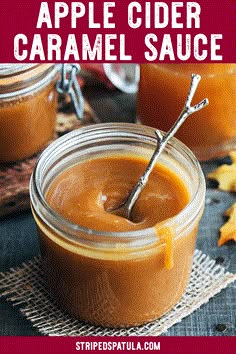 an apple cider caramel sauce in a glass jar with a spoon inside it