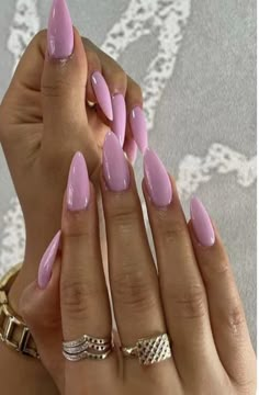 a woman's hands with pink manies and gold rings on her fingers,