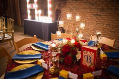 the table is set with candles, plates and napkins