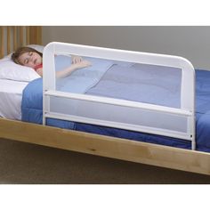 a young boy sleeping in his bed with the safety rail attached to the headboard