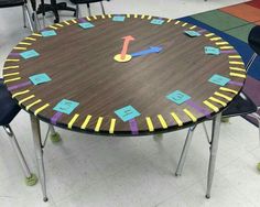 a table with several chairs around it and a clock painted on the surface in different colors