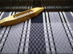 a yellow boat sitting on top of a black and white checkered table cloth