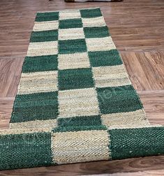 a green and white rug sitting on top of a wooden floor