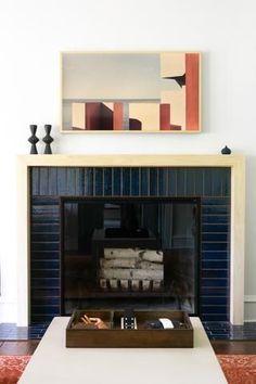 a living room with a fire place and painting on the wall above it's mantle