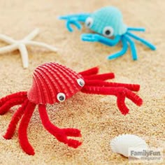 two small plastic crabs on the sand with starfish