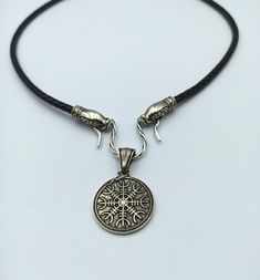 This Norse style pendant is made from Silver solid (without stamp) by hand casting. The pendant is combined the Aegishjalmur (Helm of Awe) - the icelandic magic symbol and Urnes art style ornament. The necklace is made from natural leather cord, default length 24 inch. If you like Viking or Nordic style jewelry this item I made just for you. Pendant height: 1 9/10 inch | 50 mm Pendant width: 1 1/4 inch | 32 mm Weight: 14 gm | 0.5 oz Other items in my shop: https://etsy.me/2YZKfPZ Hand Casting, Helm Of Awe, Norse Jewelry, Shield Ring, Magic Symbols, Viking Necklace, Pagan Jewelry, Viking Jewelry, Nordic Style