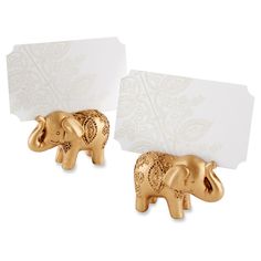 two gold elephants with blank cards in their trunks