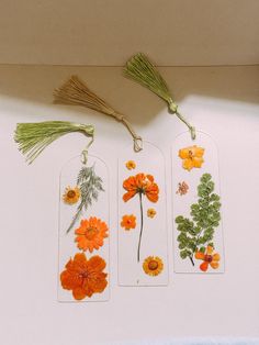 three tags with flowers are hanging on the wall