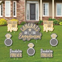 wedding engagement party yard signs in front of a house with flowers and bushes on the lawn