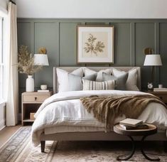 a large bed sitting next to two lamps on top of a wooden table in a bedroom