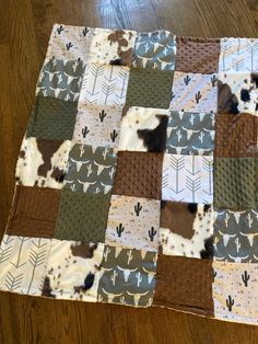 a brown and white patchwork quilt on top of a wooden floor