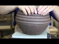 a person is making a bowl out of clay