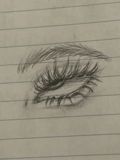 a pencil drawing of an eye with long lashes on top of lined notebooks paper