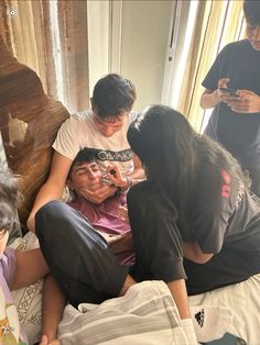 a group of people sitting on top of a bed next to each other in a room