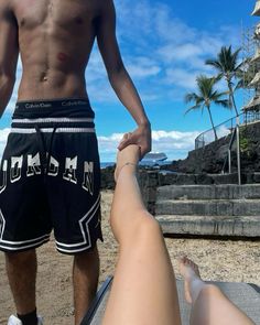 a man standing next to a woman on top of a beach