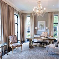 a living room filled with furniture and a chandelier hanging over it's windows