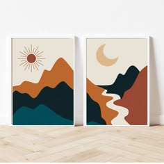 two posters with mountains and a sun in the sky, on top of a wooden floor