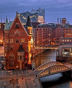 the city is lit up at night with lights on and buildings in the foreground