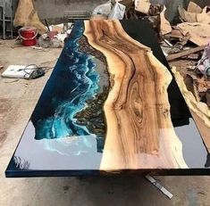 a table that is made out of wood and has blue paint on the top, along with