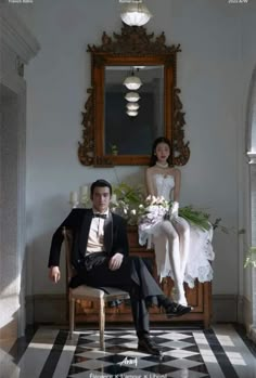 a man and woman sitting on a chair in front of a mirror next to each other