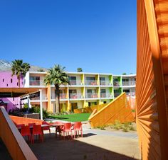 an outside view of a multi - colored building with tables and chairs