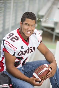 a young man is holding a football in his right hand and smiling at the camera