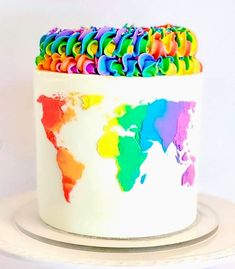 a multicolored cake with the world map on it's top and rainbow icing