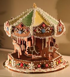 an elaborately decorated gingerbread carousel sits on a table