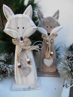 two wooden fox figurines sitting next to each other